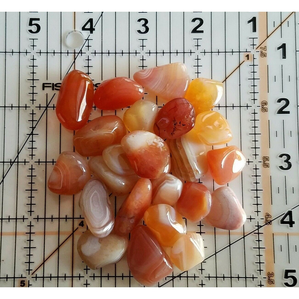 Small Tumbled Banded Carnelian Gemstones on a Measuring Mat for Size
